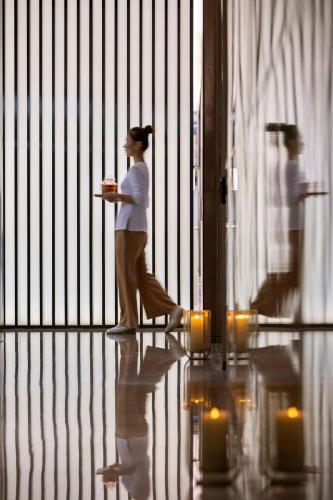 a woman walking in front of a fence at Niccolo Changsha in Changsha