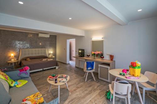a living room with a couch and a bed and tables at Lagomandra Beach Hotel in Lagomandra
