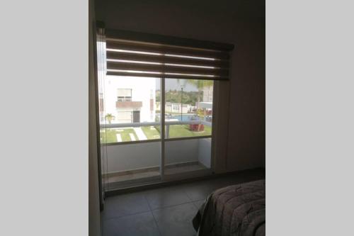 a bedroom with a window with a view of a yard at Any Mood! casa de descanso con Jacuzzi climatizado in Oaxtepec