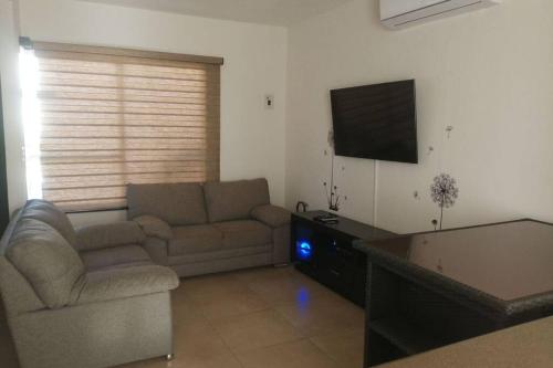 a living room with a couch and a flat screen tv at Any Mood! casa de descanso con Jacuzzi climatizado in Oaxtepec