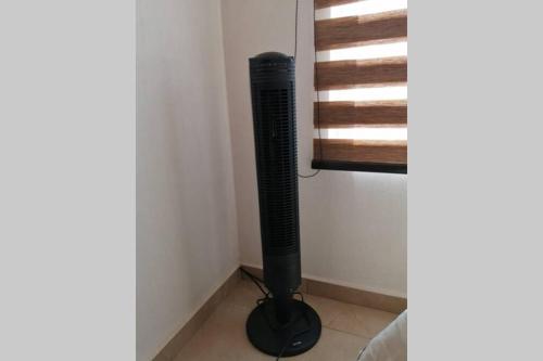 a black fan in a corner next to a window at Any Mood! casa de descanso con Jacuzzi climatizado in Oaxtepec
