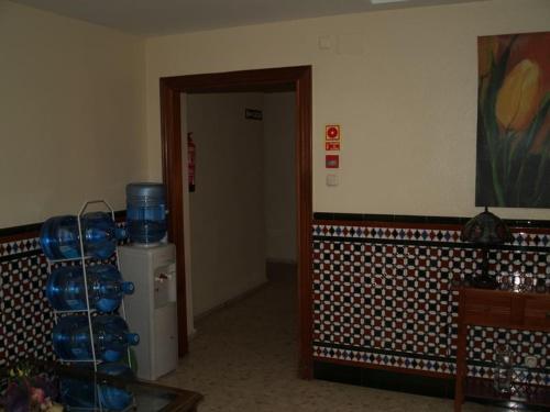 a hallway with a room with a door and a room with blue bowls at Hostal Carlos III in El Ejido