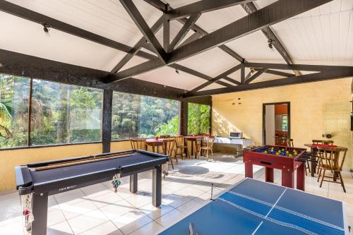 a room with a pool table and tables at Pousada Atibaia in Atibaia