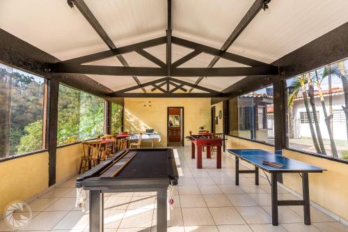 a room with two ping pong tables and windows at Pousada Atibaia in Atibaia