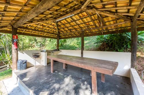 a wooden bench sitting under a wooden roof at Pousada Atibaia in Atibaia