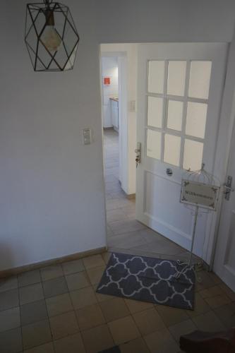 a hallway with a room with a door and a rug at Pension Zweite Heimat in Wörth am Main