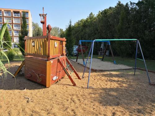 a playground with a swing set in a park at Panoráma906 Apartman in Siófok