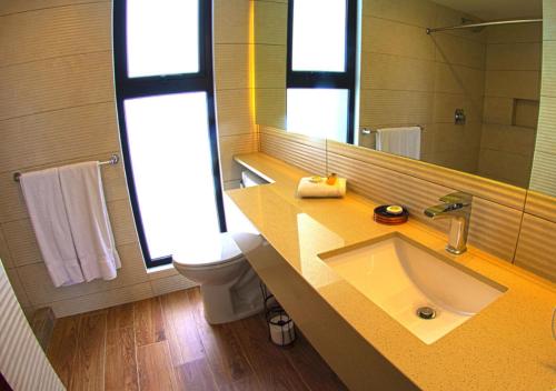 a bathroom with a sink and a toilet and a mirror at Suites Terraza Imperial in Guatemala