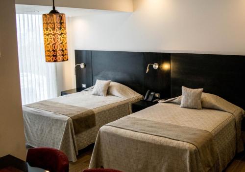 a hotel room with two beds and a window at Suites Terraza Imperial in Guatemala