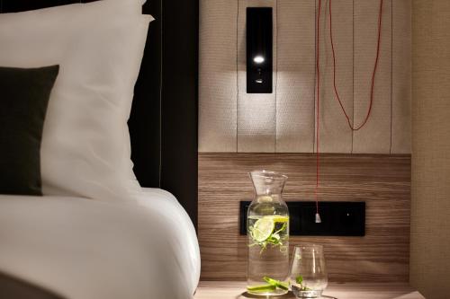 a glass vase sitting on a table with two glasses at Crowne Plaza - Warsaw - The HUB by IHG in Warsaw