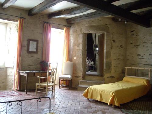 une chambre avec un lit, une table et des chaises dans l'établissement La Tour des Laudes, à Breuil-Barret