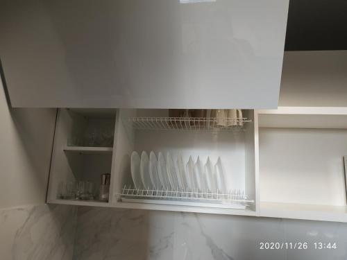a kitchen cabinet with white vases in it at Дуже файна квартира в самому центрі!!!!Переконайся!! in Rivne