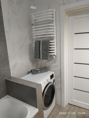 uma máquina de lavar e secar roupa numa casa de banho ao lado de uma porta em Дуже файна квартира в самому центрі!!!!Переконайся!! em Rivne