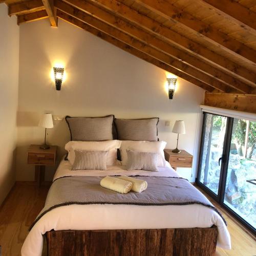 a bedroom with a large bed with two pillows at Quinta do Ovelheiro in Guimarães
