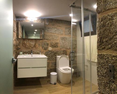 a bathroom with a toilet and a sink and a shower at Quinta do Ovelheiro in Guimarães