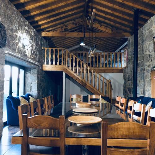 a dining room with a table and chairs and a staircase at Quinta do Ovelheiro in Guimarães