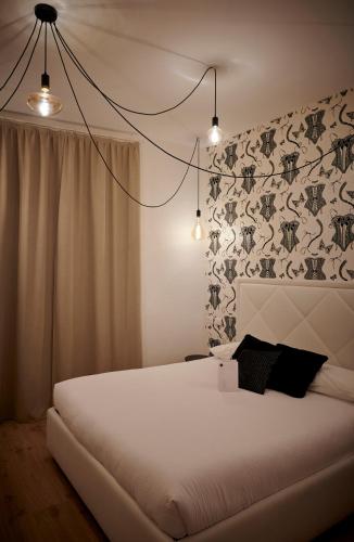 a bedroom with a white bed with a floral wallpaper at Lainez Rooms & Suites in Trento