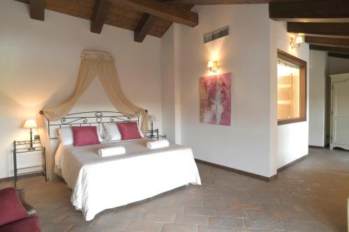 a bedroom with a large bed with red pillows at Relais Bella Rosina Pool & Spa in Fiano