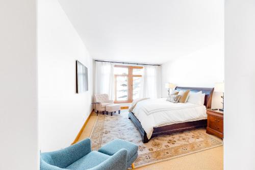 um quarto com uma cama e duas cadeiras azuis em Legends Hideout em Sun Valley