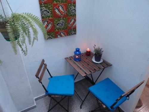 een kleine tafel met twee blauwe stoelen en een kaars bij Lisbon City Centre Apartment in Lissabon