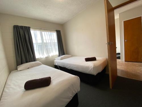 a hotel room with two beds and a window at Ulster Apartments in Hamilton