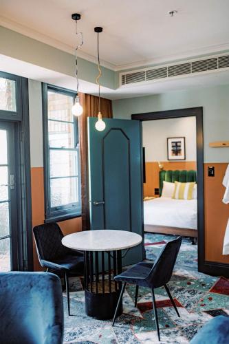 a hotel room with a bed and a table and chairs at Stay at Hotel Steyne in Sydney