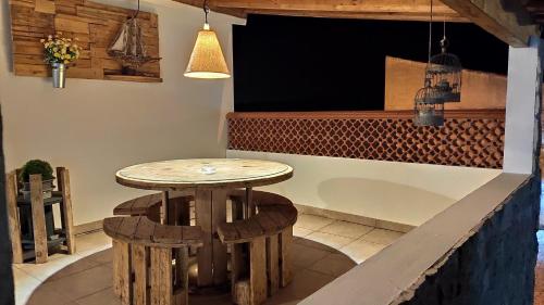 Una mesa y dos taburetes delante de una barra. en Casa D Amélia, en Óbidos