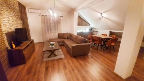 ein Wohnzimmer mit einem Sofa und einem Tisch in der Unterkunft Gold Apartment in Strumica