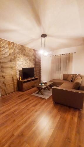 a living room with a couch and a tv at Gold Apartment in Strumica