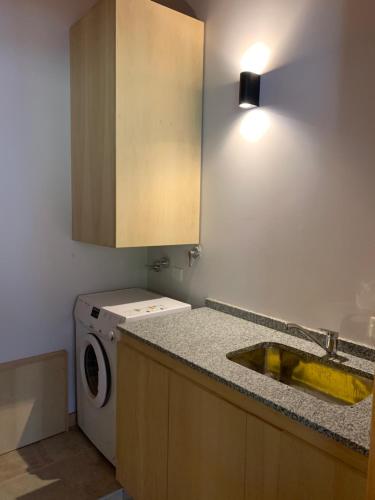 cocina con fregadero y lavadora en Exclusivo departamento cerca del lago en San Martín de los Andes