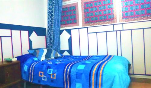 een slaapkamer met een bed met een blauw dekbed bij Cuarto entrada independiente privado solo para ti narvarte roma valle cerca Hospitales Centro Médico SXXI y Macgregor Regional IMSS 1 Parque Delta Narvarte WTC in Mexico-Stad