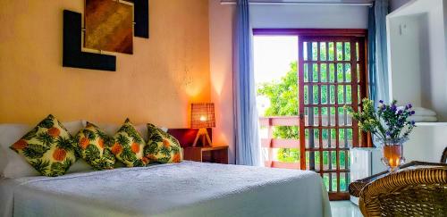 a bedroom with a bed and a door with a window at Bem Bahia Hotel - Rede Bem Bahia in Porto Seguro
