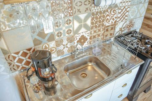 a kitchen counter with a sink with a coffee maker at Loft Casa no Farol in Laguna