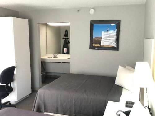 a hotel room with a bed and a sink at BestWay Inn Oklahoma City Airport in Oklahoma City