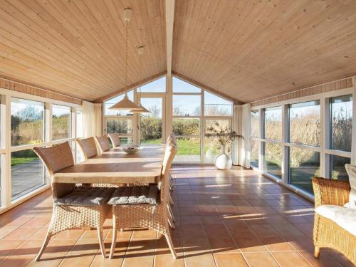 uma sala de jantar com uma mesa de madeira e cadeiras em 6 person holiday home in Hj rring em Sønderlev