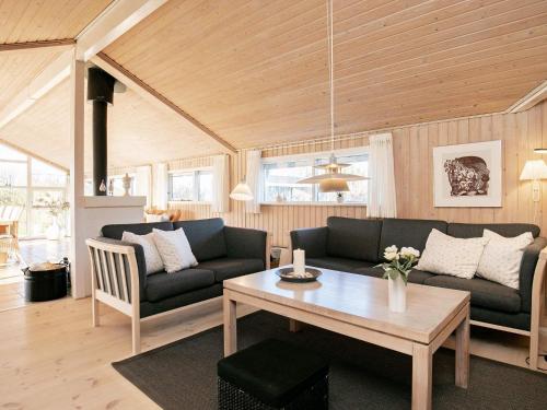 een woonkamer met 2 banken en een tafel bij 6 person holiday home in Hj rring in Sønderlev