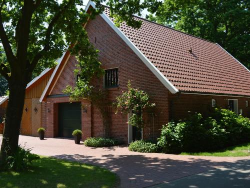 a red brick building with a garage at Holiday home in Lindern with garden in Werlte