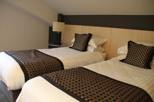 a hotel room with two beds in a room at The Ridge Hakuba Hotel & Apartments in Hakuba