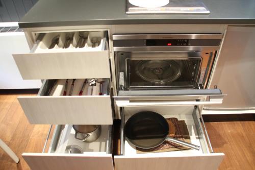 a kitchen with a stove and a dishwasher at The Ridge Hakuba Hotel & Apartments in Hakuba