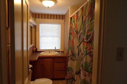 baño con lavabo y aseo y ventana en Winnisquam Lake House, en Tilton