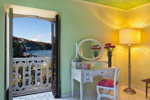 a room with a dressing table and a mirror and a balcony at Maison Alice in Sorrento