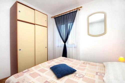 - une chambre avec un lit doté d'un oreiller bleu dans l'établissement Apartments and rooms Cherry - relax & chill by the pool, à Novalja