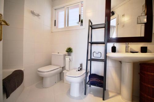 une salle de bain avec toilettes, lavabo et miroir dans l'établissement Golden Paradise 75 by homeprive, à Jávea