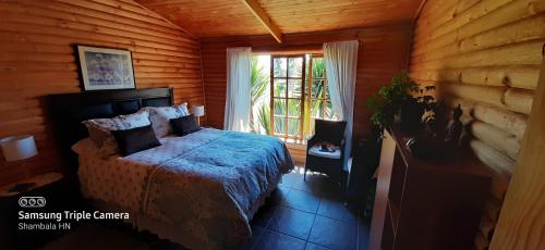 a bedroom with a bed and a large window at B&B Shambala HN in Pelarco