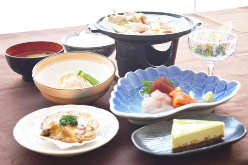 a table with plates of food and bowls of food at Nayoro Onsen Sunpillar in Nayoro