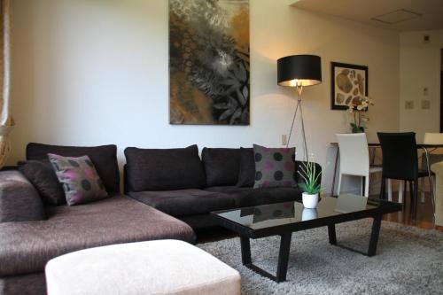a living room with a couch and a coffee table at The Ridge Hakuba Hotel & Apartments in Hakuba