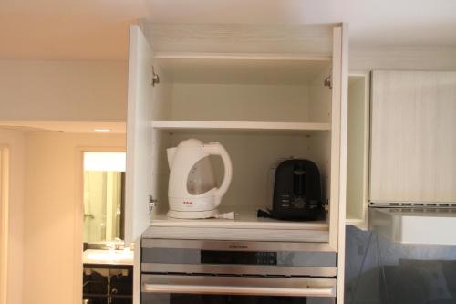 a kitchen cabinet with a white appliance in it at The Ridge Hakuba Hotel & Apartments in Hakuba