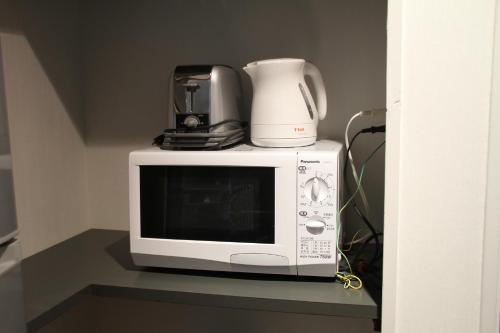 a microwave with a blender on top of it at The Ridge Hakuba Hotel & Apartments in Hakuba