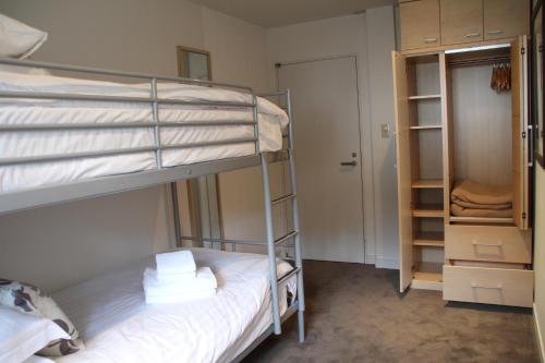 a bedroom with two bunk beds and a closet at The Ridge Hakuba Hotel & Apartments in Hakuba