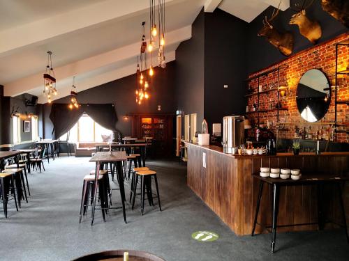 a restaurant with a bar and some tables and chairs at The River Inn Thredbo in Thredbo